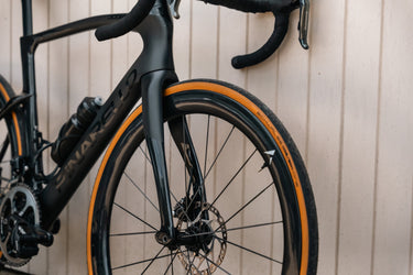 Close-up of Velocite carbon road bike wheel with tan sidewalls, engineered for speed and precision in the UK market.