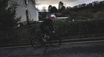 Cyclist riding in the evening light through a village street.