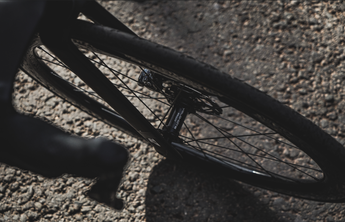 Close-up of a rear Velocite bike wheel hub and spokes on a road surface.